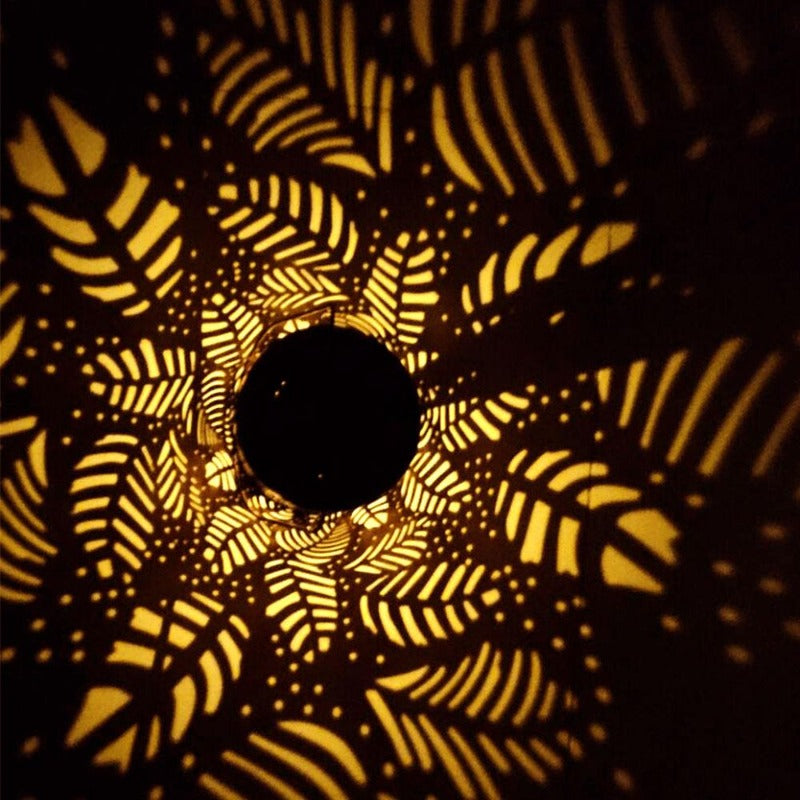 Linterna solar para exteriores con diseño de hojas y sombras proyectadas