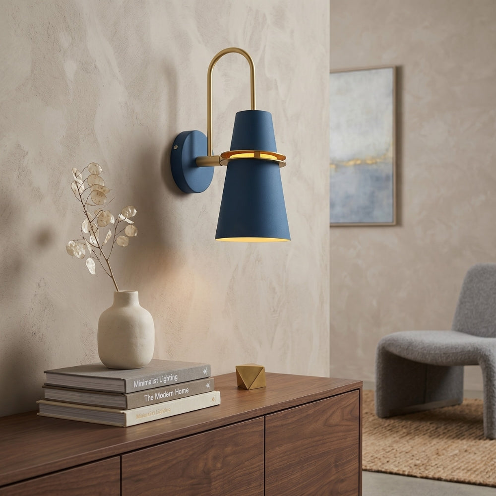 Modern wall sconce with blue shade and gold accents on a wooden cabinet.