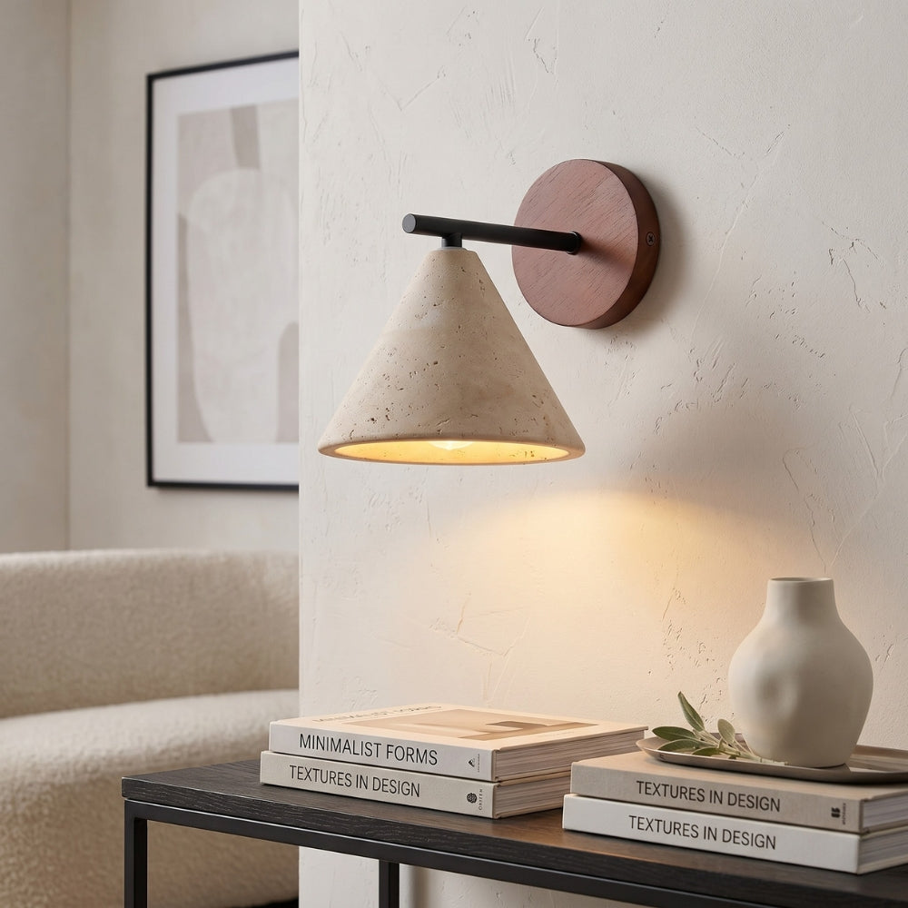 Wallscon wall lamp on a white wall with books and a vase on a table below.