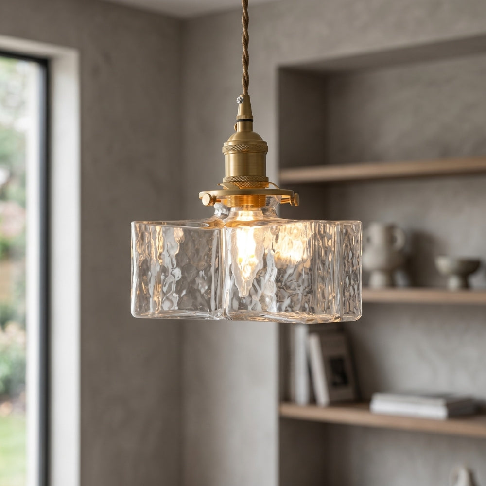 Vintage-style pendant light with clear glass shade and brass fixture in a home setting.