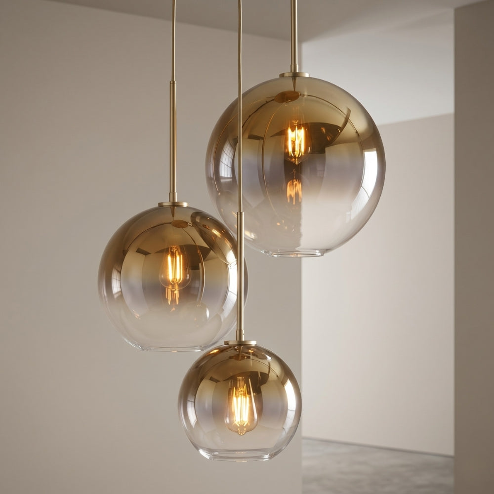 Modern pendant light with glass shades and gold fixtures against a neutral background