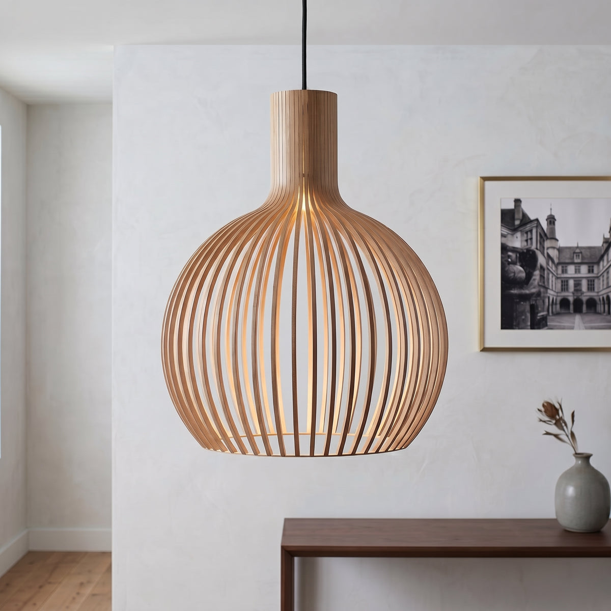 Wooden pendant lamp hanging in a room with a table and vase.