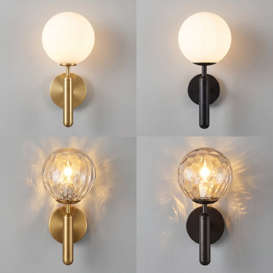 Four wall sconces shown in a 2x2 grid, each with a spherical globe shade and a cylindrical backplate. Two sconces have warm brass/gold finishes and two have black finishes.
