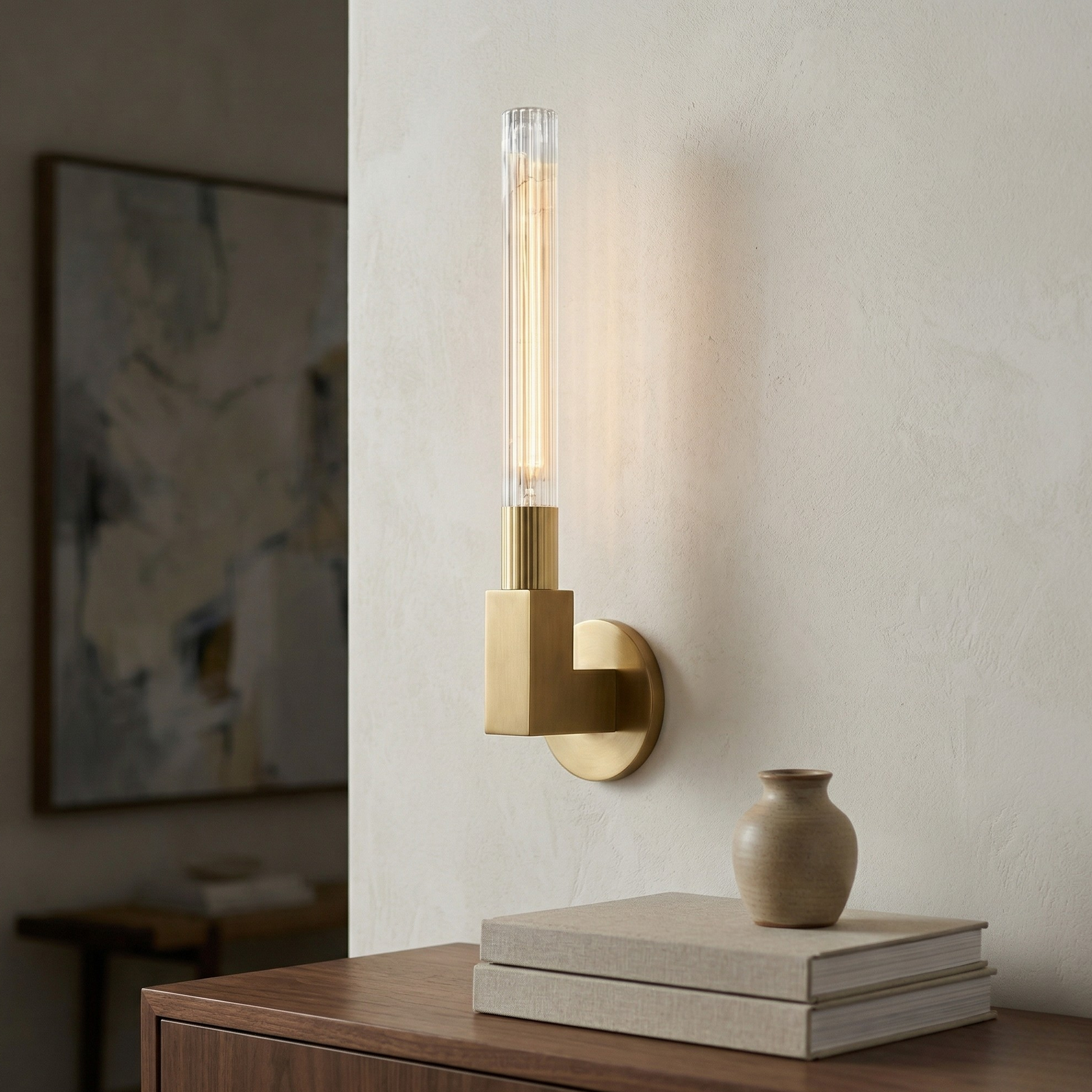 Modern wall sconce with a vase and books on a wooden surface.